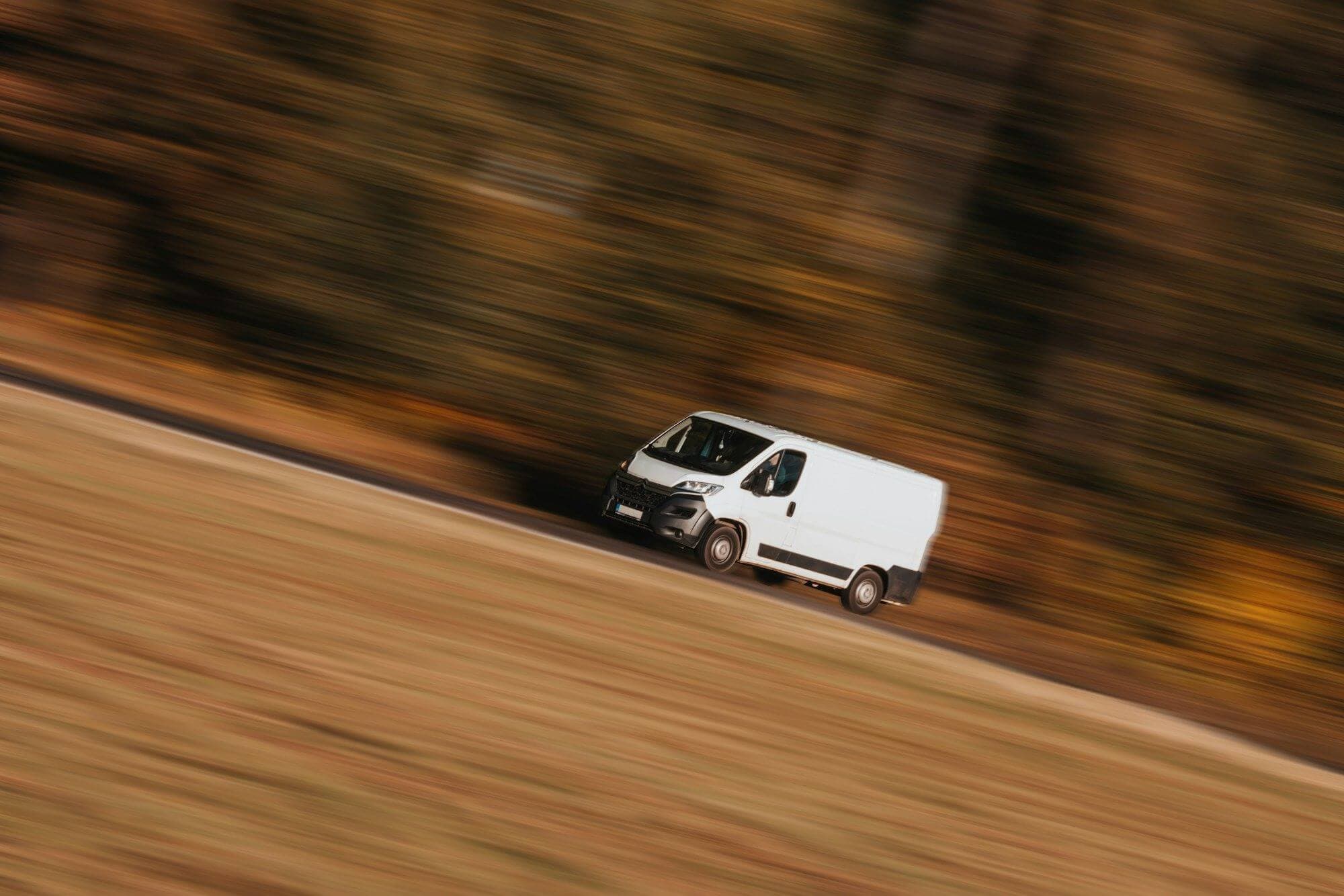 Delivery van speeding along a road, motion-blurred
